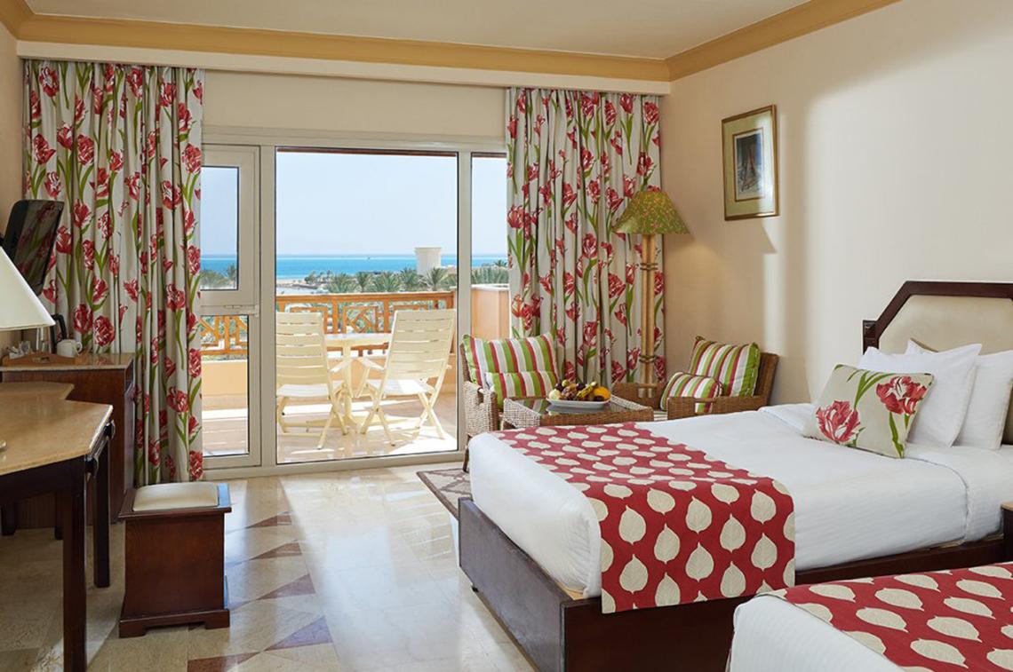 Doppelzimmer mit Balkon im Continental Hotel Hurghada, mit Blick auf das Meer und Möbeln auf dem Balkon.