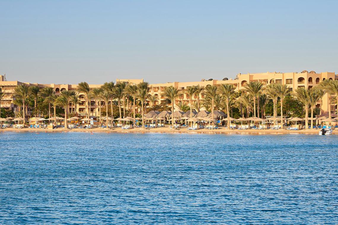 Außenansicht des Continental Hotel Hurghada mit Blick auf die Palmen und den Strand.