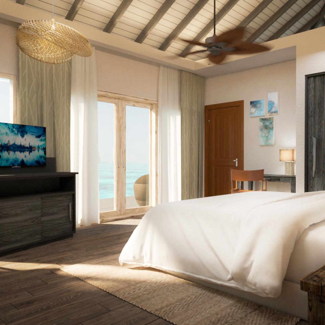 Schlafzimmer mit Meerblick im You & Me Maldives Hotel mit Fernseher, Bett und Schreibtisch.