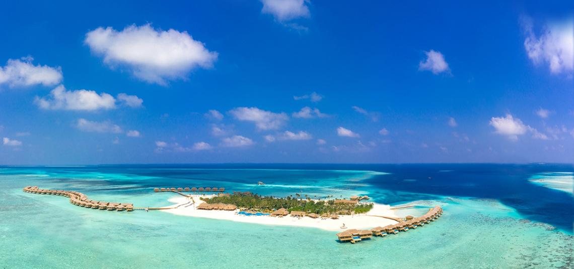 Luftaufnahme des You & Me Maldives Hotels auf einer Insel im Indischen Ozean.