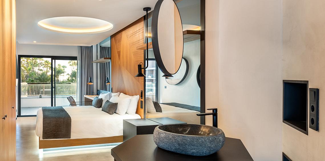 Hotelzimmer im Faro, einem Lopesan Collection Hotel, mit Bett, Badezimmer und modernem Design.