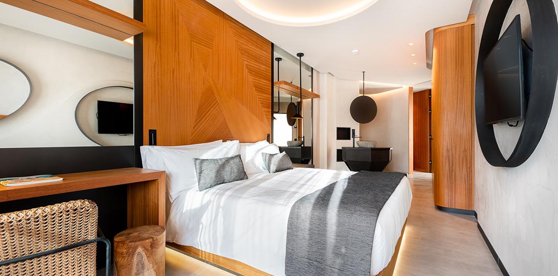 Hotelzimmer im Faro, a Lopesan Collection Hotel mit einem großen Bett, weißen Kissen und einer grauen Decke.
