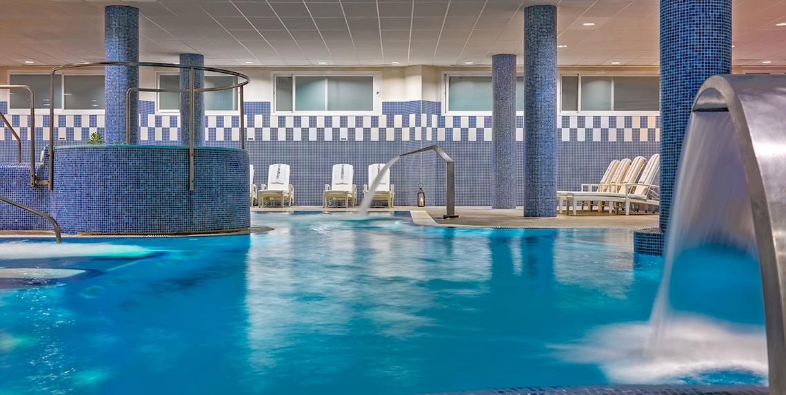 Innenpool des H10 Estepona Palace mit blauen Fliesen und Wasserfällen