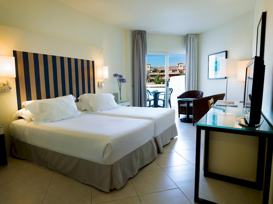 Doppelzimmer im H10 Estepona Palace mit zwei Betten, Balkon und Ausblick auf Außenterrasse