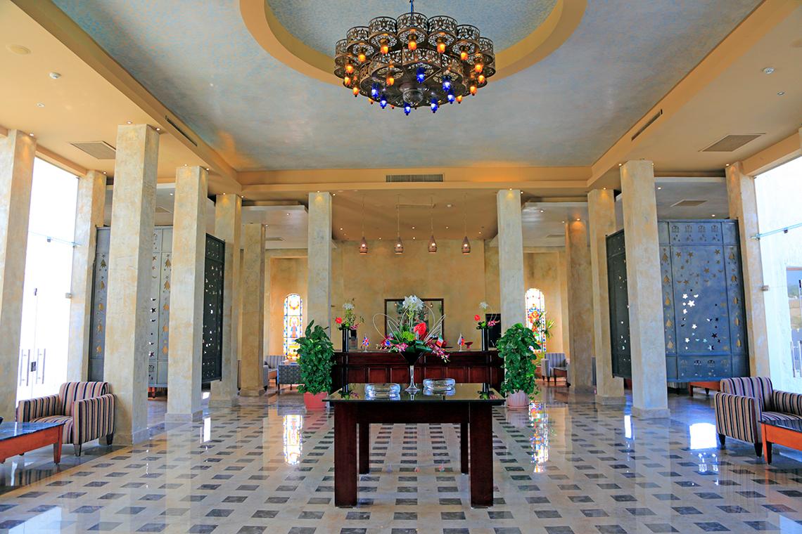 Empfangsbereich des Sharm Club Beach Resorts mit zentralem Kronleuchter und gemustertem Boden.