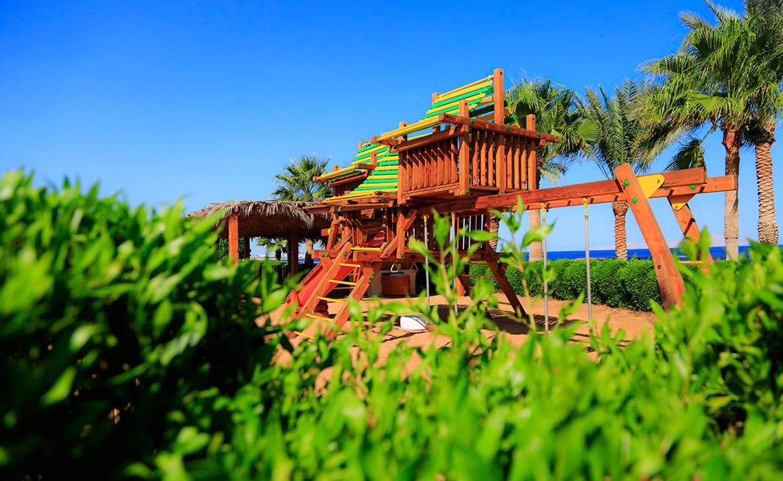 Kinderspielplatz im Sharm Club Beach Resort mit einer Rutsche und einem Klettergerüst.