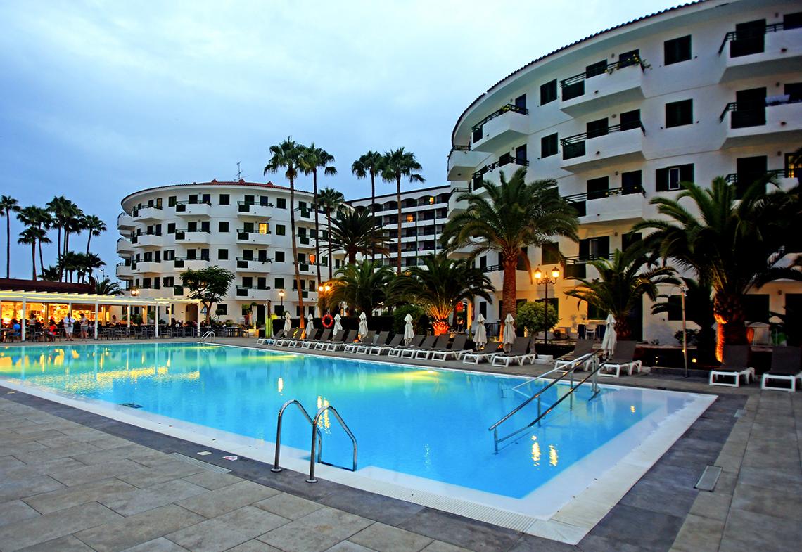 Poolbereich des Hotels Servatur Playa Bonita mit Liegestühlen und Palmen