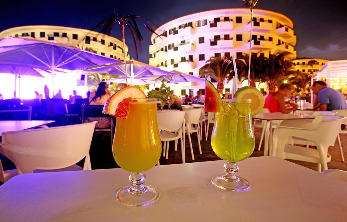 Zwei Cocktails auf einem Tisch vor dem Hotel Servatur Playa Bonita bei Nacht