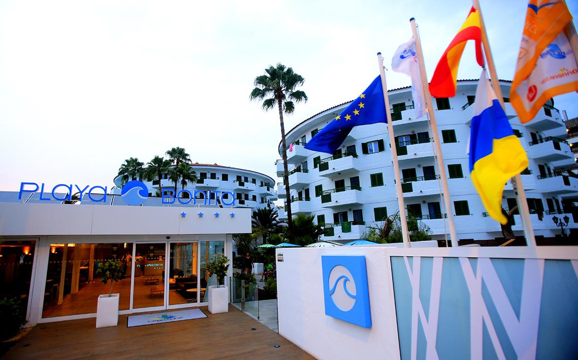 Eingang des Hotels Servatur Playa Bonita mit Fahnen und Palmen