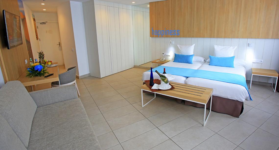 Zimmer im Servatur Playa Bonita mit zwei Betten, Tisch und Obst