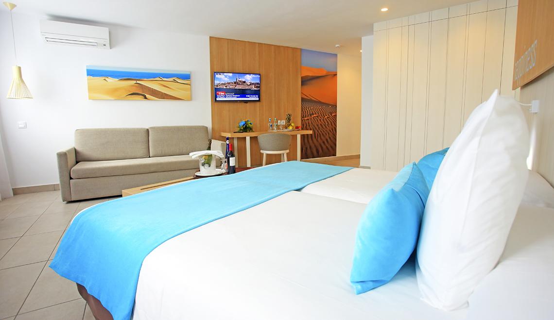 Zimmer im Servatur Playa Bonita mit Bett, Sofa und Wäsche