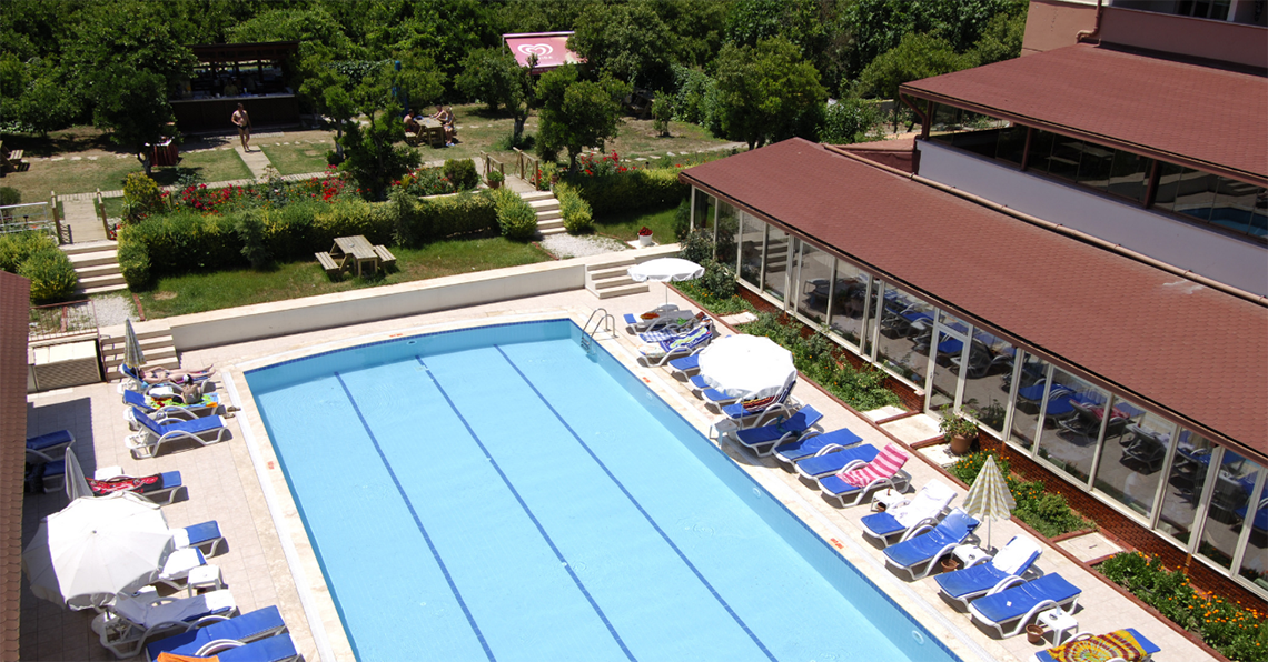 Pool-Außenbereich des Swandor Hotels & Resorts Topkapi Palace mit Liegestühlen und Sonnenschirmen.
