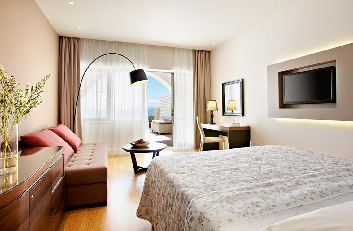 Ein Schlafzimmer im MarBella Corfu Hotel mit Blick auf das Meer.