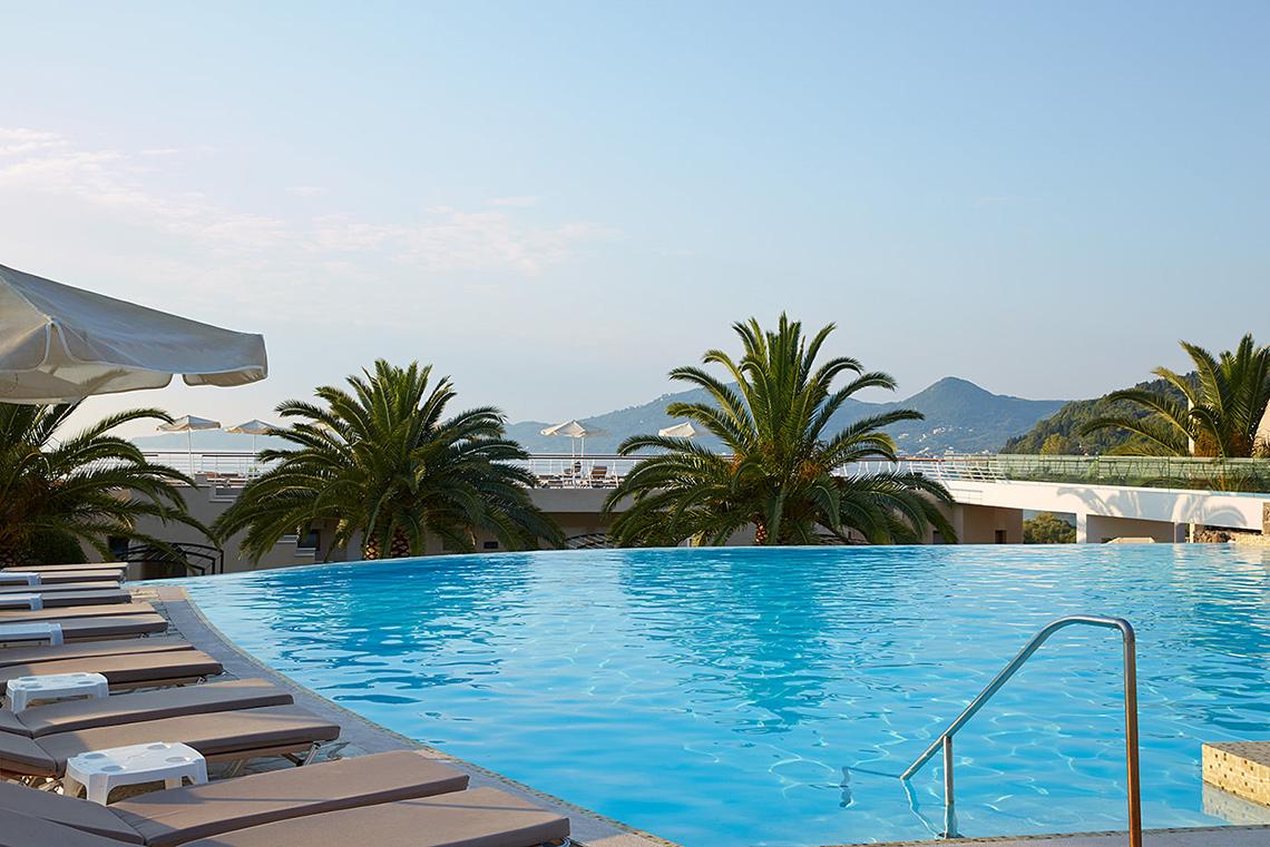 Außenpool des MarBella Corfu Hotels mit Sonnenliegen und Palmen