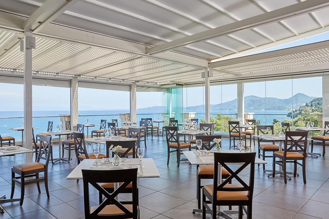 Innenansicht des Restaurants im MarBella Corfu Hotel mit Blick auf das Meer und die Berge