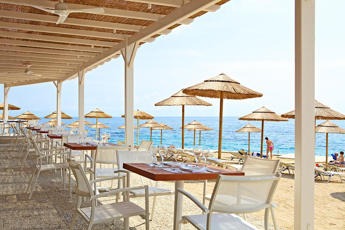 MarBella Corfu Hotel - Restaurant am Strand mit Sonnenschirmen und Tischen.