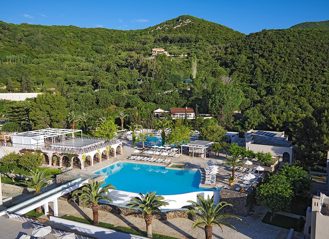 Luftaufnahme des MarBella Corfu Hotels mit Pool, Liegen und Gebäuden in grüner Umgebung.