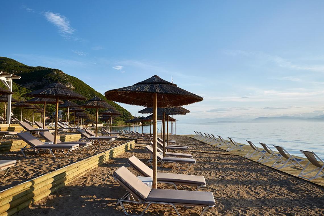 MarBella Corfu Hotel Strand mit Liegen und Sonnenschirmen