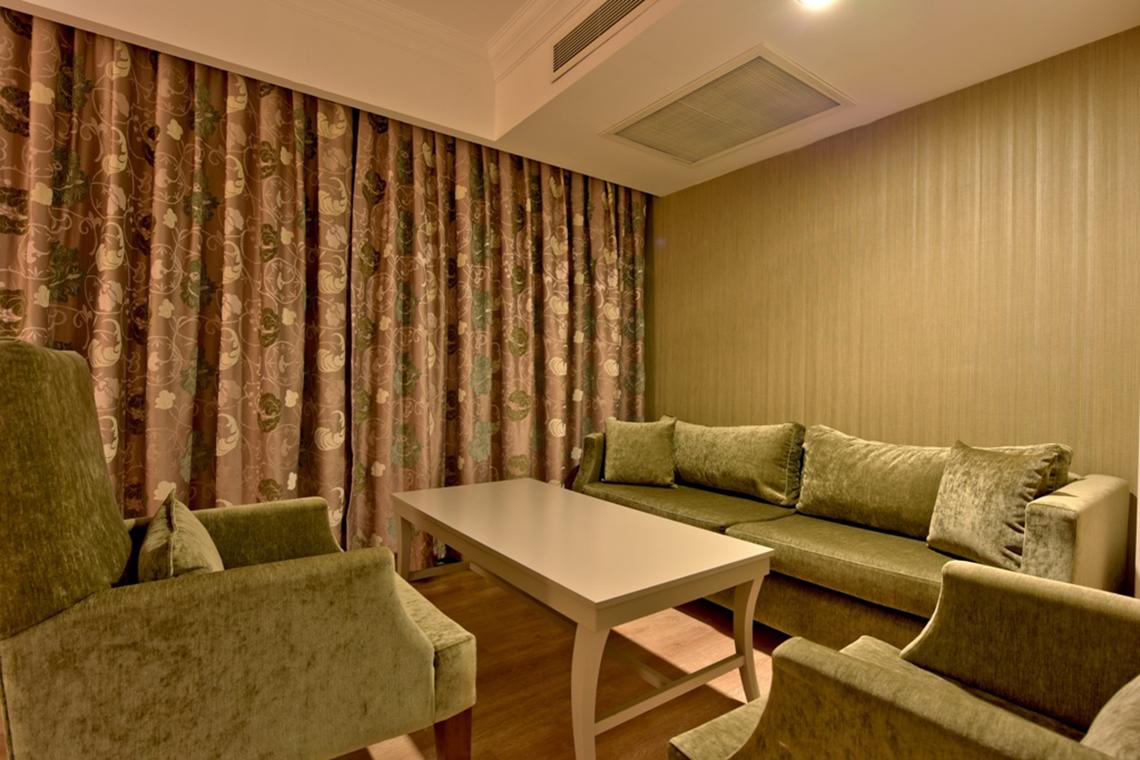 Wohnzimmer im Side Star Resort mit grünen Möbeln, einem Tisch und einem Sofa.