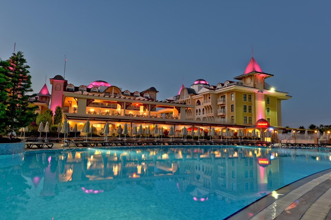 Abendlicher Blick auf das Side Star Resort mit Pool und vielen leuchtenden Dekorationen.
