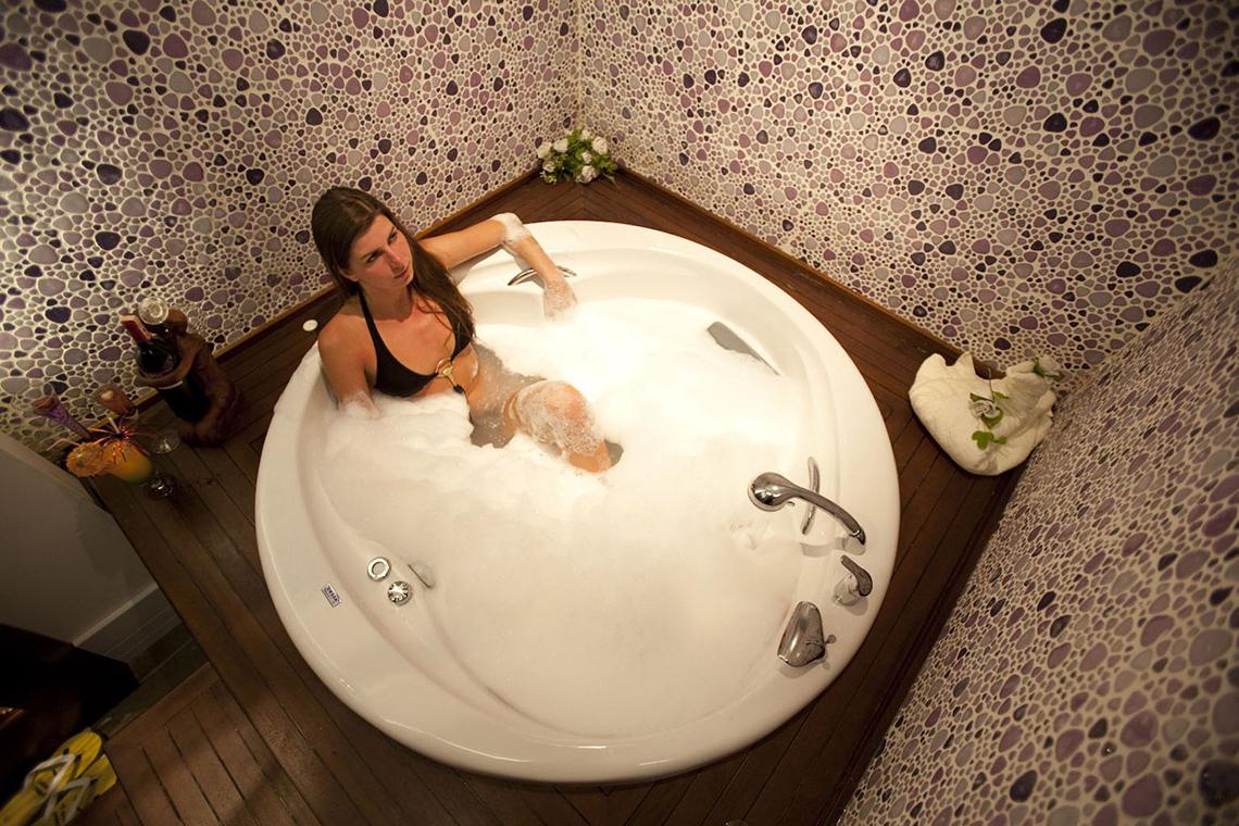 Frau in einer weißen Badewanne voller Schaum im Side Star Resort