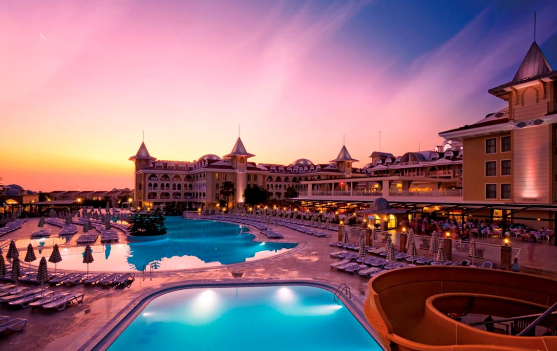 Sonnenuntergang über dem Side Star Resort Hotel mit Swimmingpools und Liegestühlen