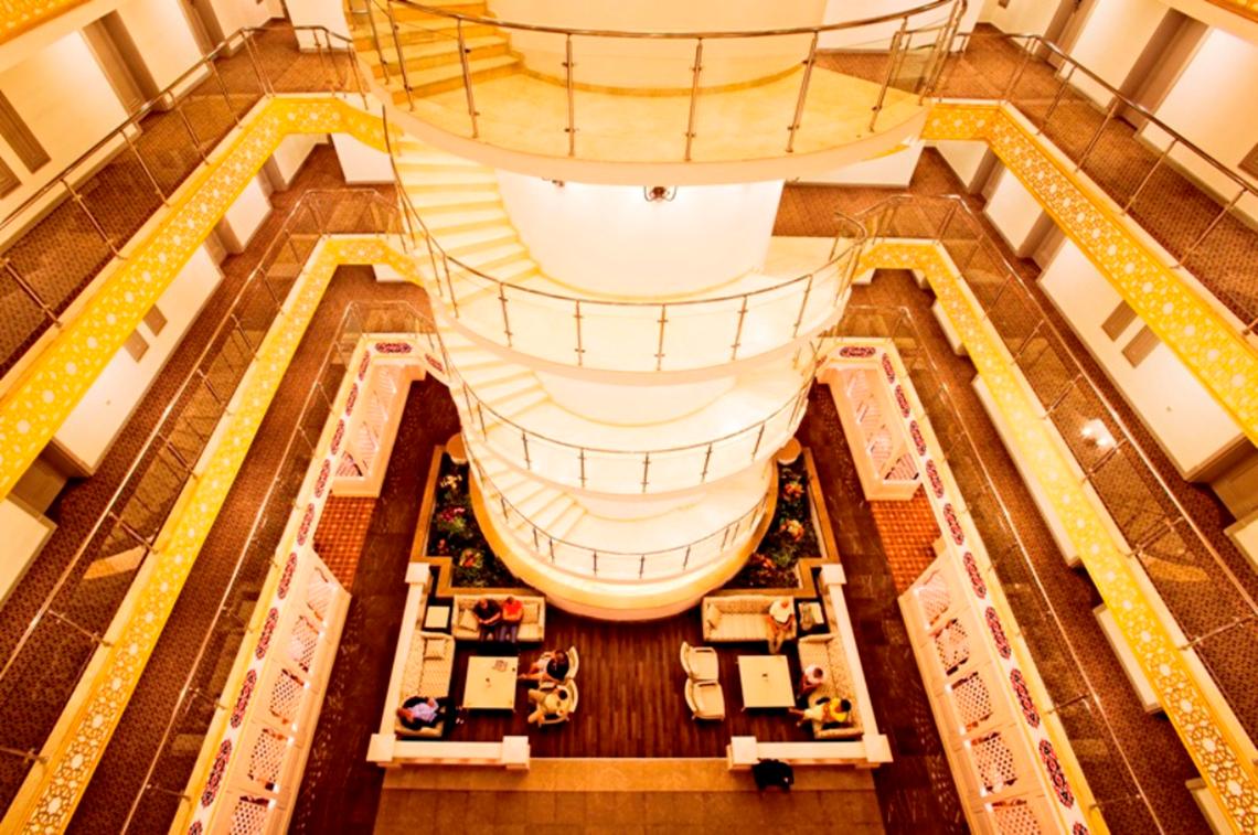 Innenansicht der Lobby des Side Star Resort mit einer zentralen Wendeltreppe und Sitzbereichen.
