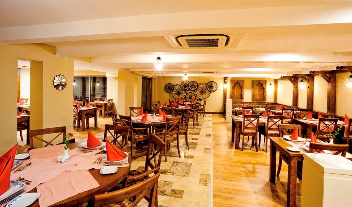 Innenansicht des Restaurants im Side Star Resort mit gedeckten Tischen und Stühlen.