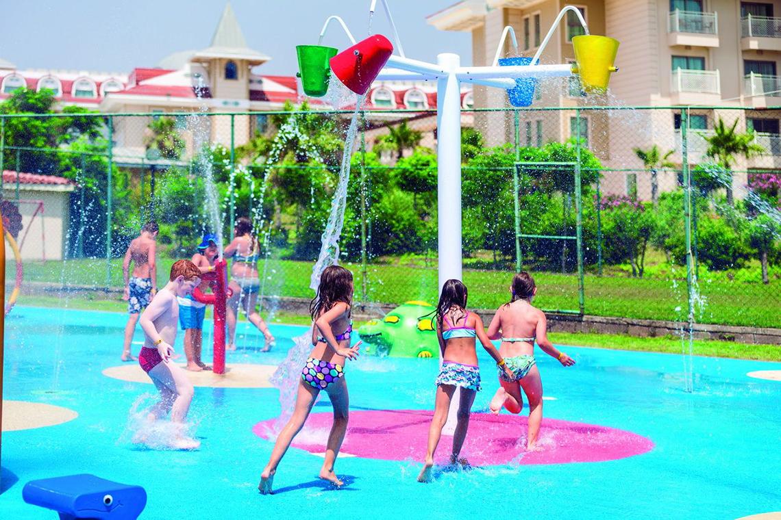 Kinder spielen auf einem Wasserspielplatz im Freibad des Side Star Resort.