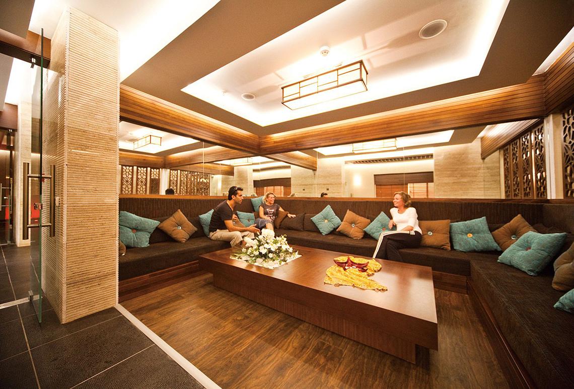 Lobby-Lounge im Side Star Resort mit drei Personen auf einer Couch und einem Tisch