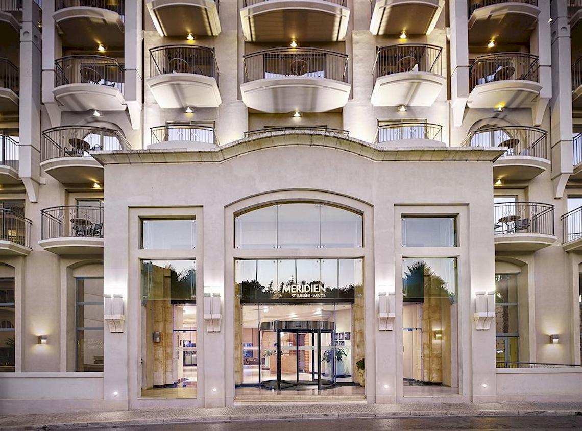 Vorderansicht des Malta Marriott Hotel & Spa mit gläsernem Eingang und Balkonen