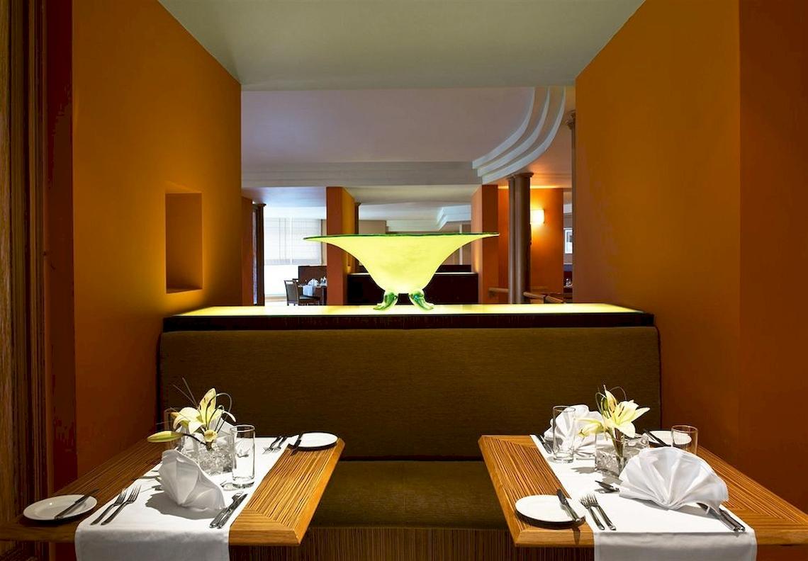 Restauranttisch im Malta Marriott Hotel & Spa mit dekorativen Elementen und Blick auf eine gelbe Leuchte.