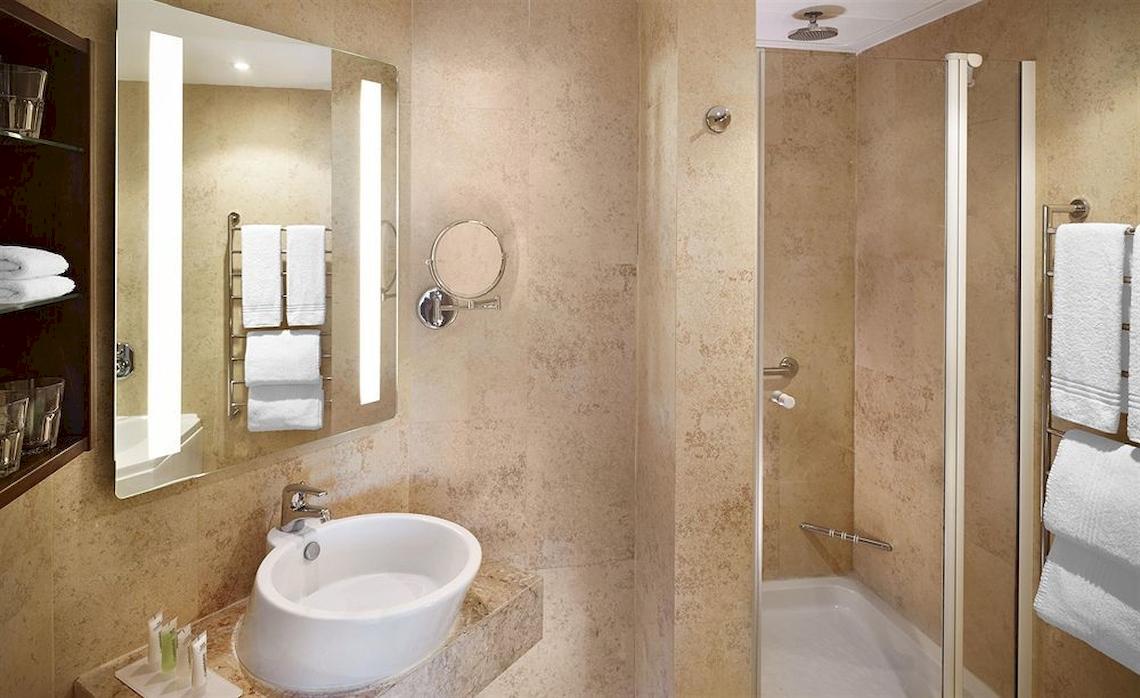 Badezimmer im Malta Marriott Hotel & Spa mit Waschbecken, Spiegel und Dusche.