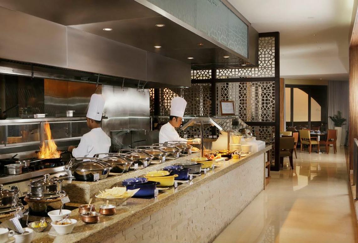 Küche des Amwaj Rotana Hotels mit Köchen und serviertem Essen.