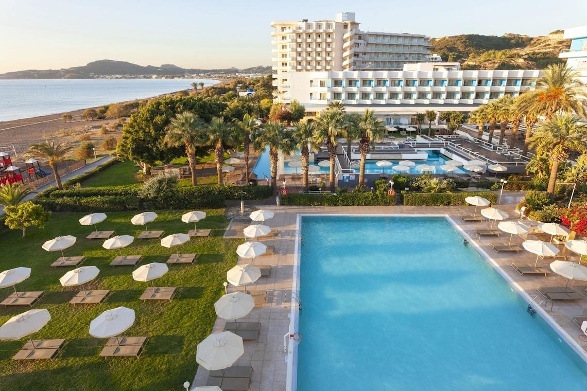 Luftaufnahme des Blue Sea Beach Resorts mit Swimmingpools, Sonnenliegen und Palmen.