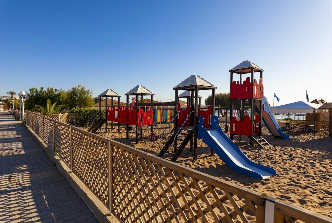 Kinderspielplatz im Blue Sea Beach Resort mit bunten Spielgeräten und einem blauen Rutschen