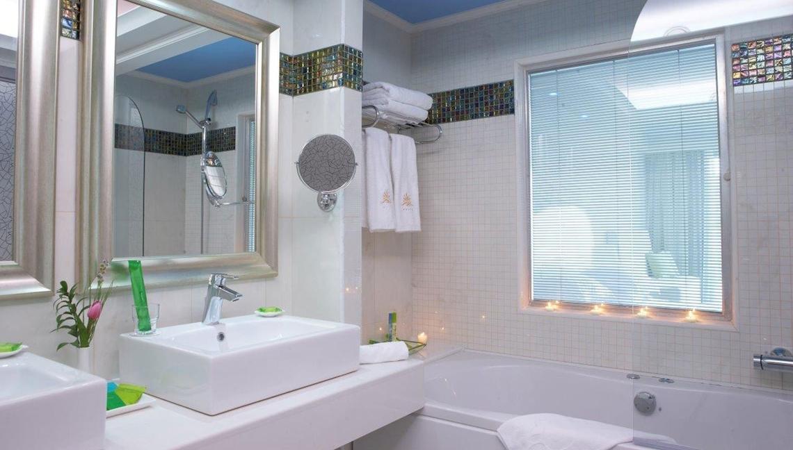 Badezimmer im Atrium Platinum Luxury Resort Hotel & Spa mit Badewanne, Waschbecken und Spiegel.