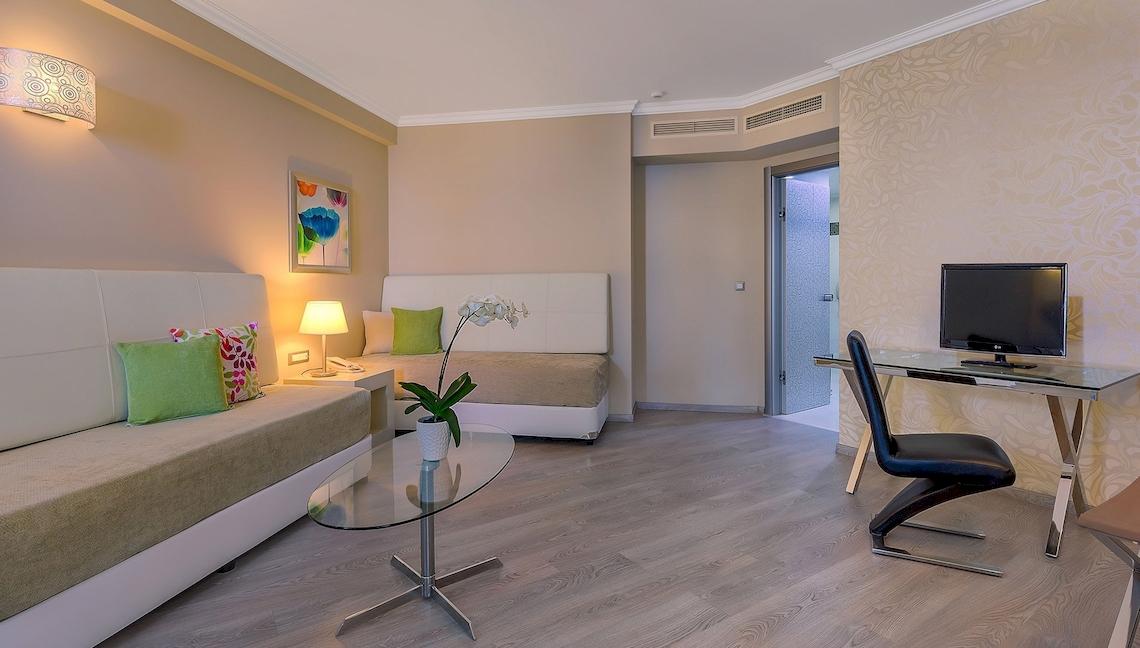 Hotelzimmer mit einem Schlafbereich, einem Schreibtisch und einem Fernseher.