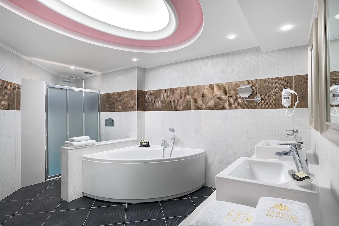Badezimmer mit Badewanne, zwei Waschbecken und Dusche im Atrium Platinum Luxury Resort Hotel & Spa.