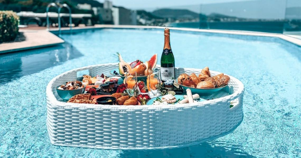 Frühstücksbuffet auf einem weißen Tablett im Schwimmbad des Atrium Platinum Luxury Resort Hotel & Spa.