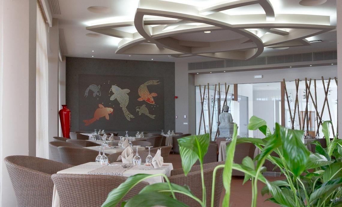 Innenansicht des Atrium Platinum Luxury Resort Hotel & Spa mit runden Decken und Koi-Fisch-Wandmalereien.