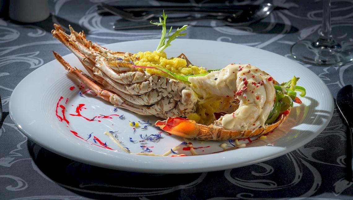 Essen im Atrium Platinum Luxury Resort Hotel & Spa, ein Hummergericht mit Garnelen und Beilagen.