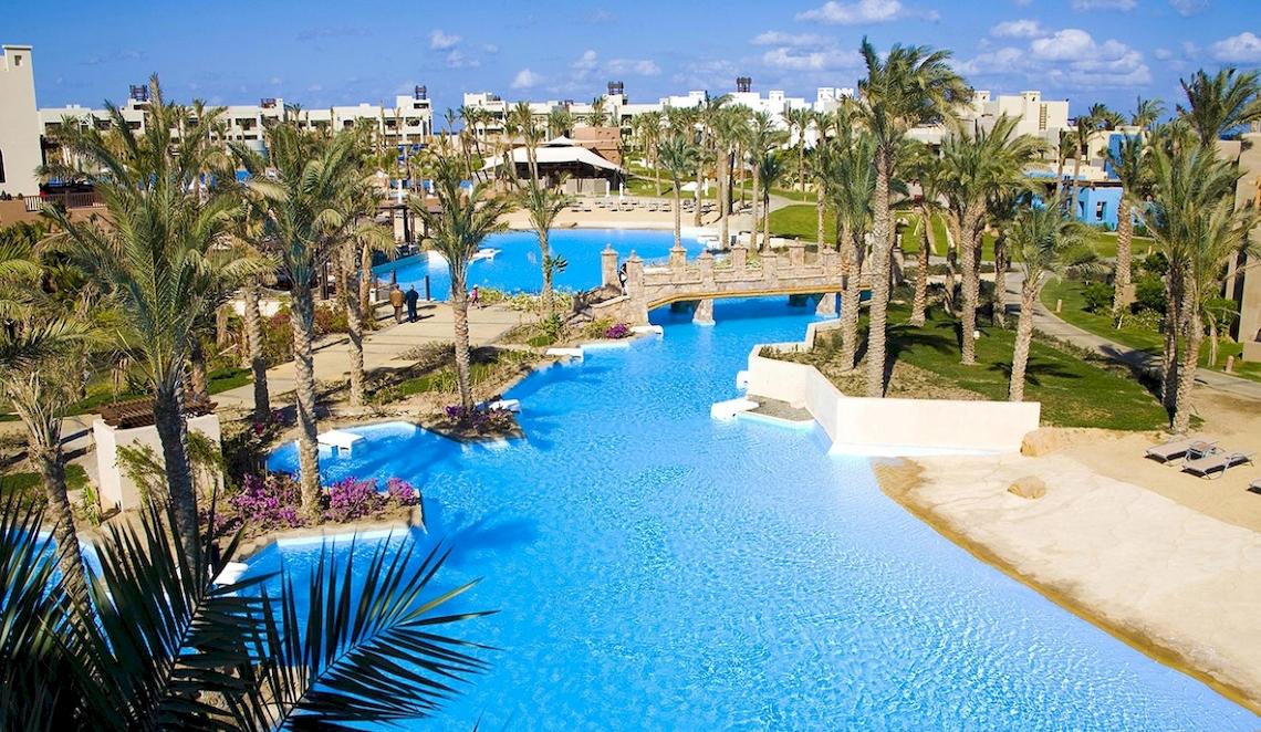 Luftaufnahme des Pools im PickAlbatros Sands Port Ghalib Hotelresort mit Brücke und Palmen