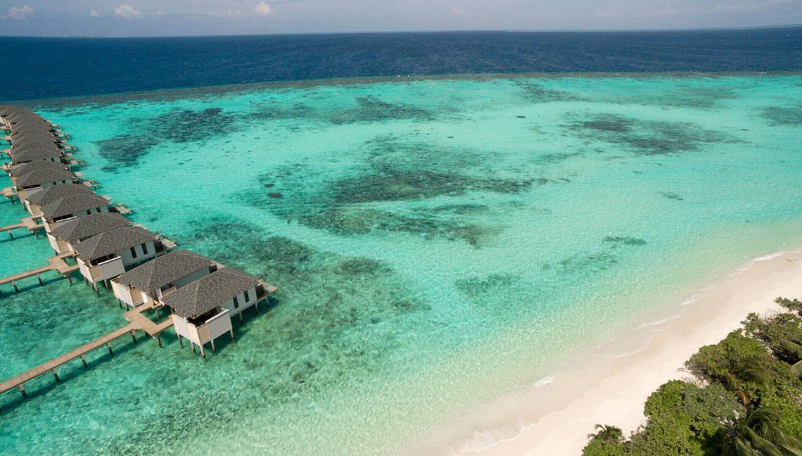 Luftaufnahme von Amari Havodda Malediven Wasservillen am Strand