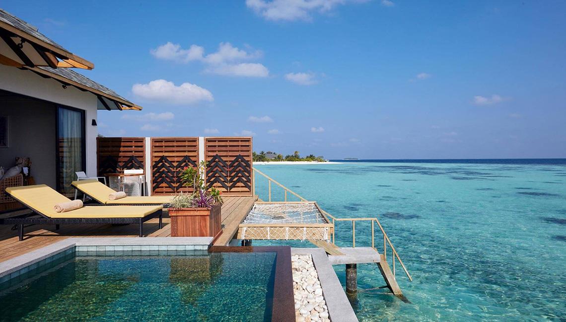 Außenpool mit Liegen und Meerblick im Amari Havodda Maldives Hotel.