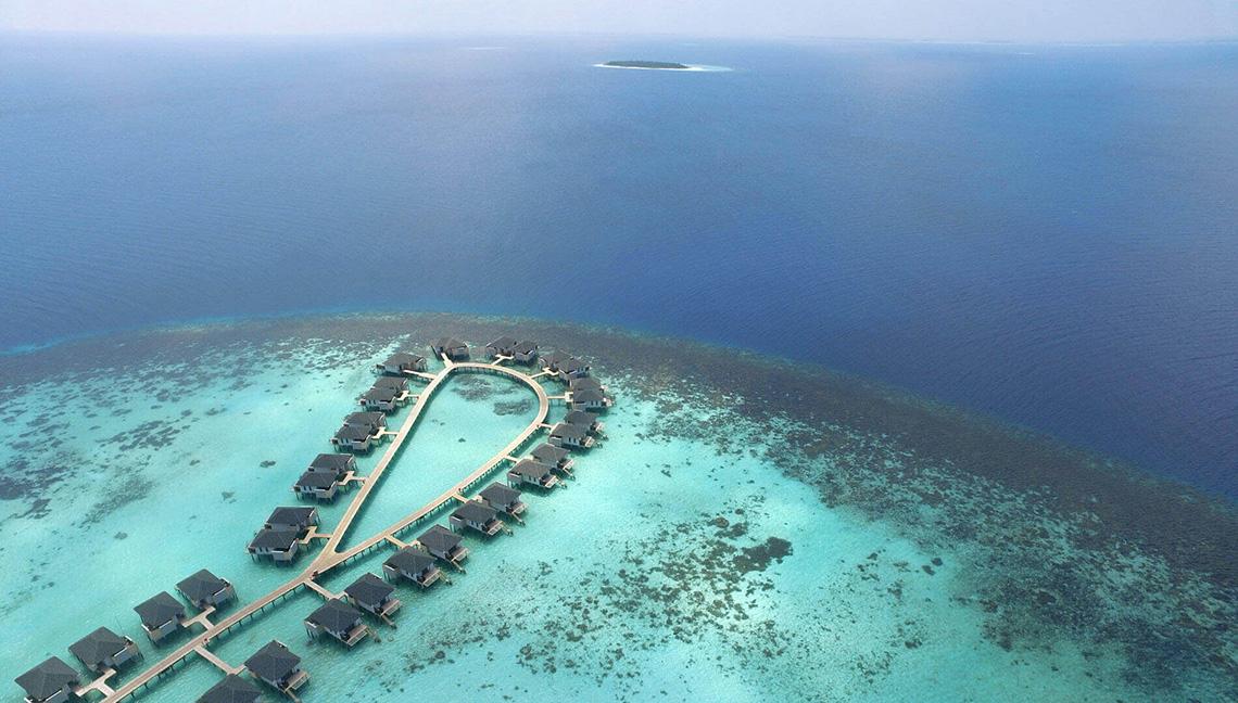Luftaufnahme des Amari Havodda Maldives Resorts mit Wasservillen im Ozean