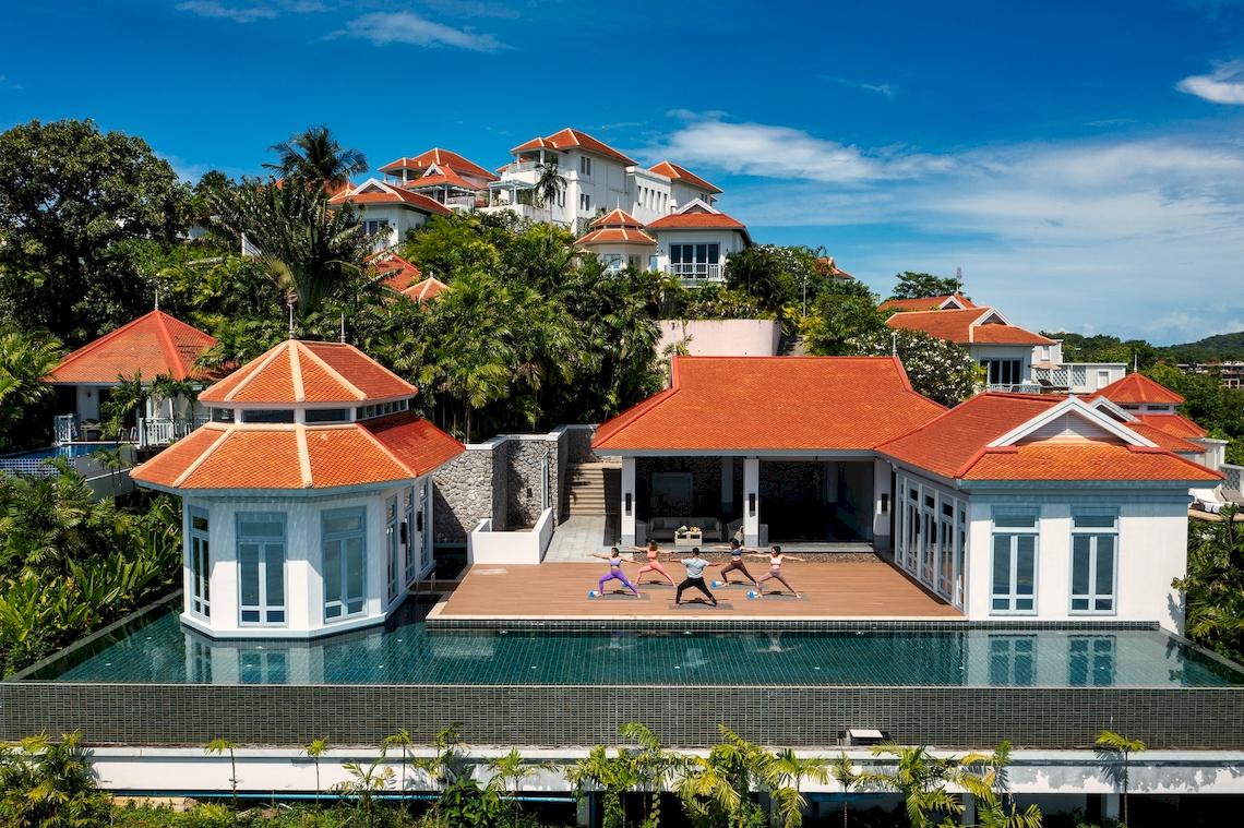 Luftaufnahme des Amatara Welleisure Resorts mit Yoga-Praktizierenden am Pool.