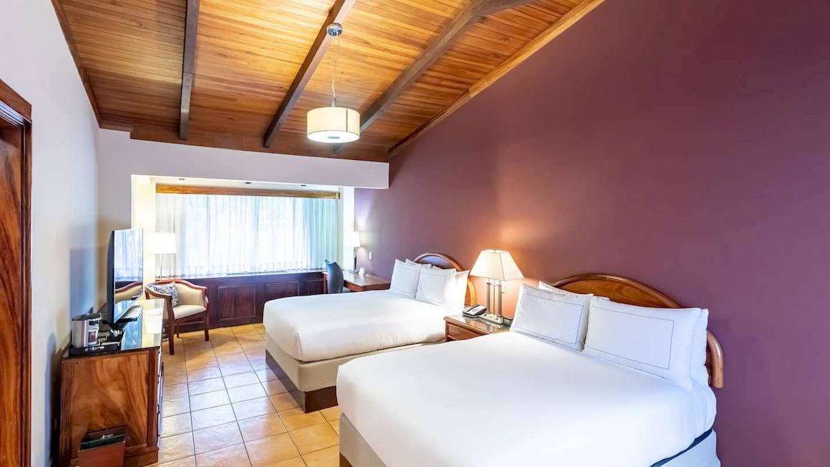 Doppelzimmer im DoubleTree by Hilton Hotel Cariari San Jose mit zwei Betten, Fernseher und Schreibtisch.