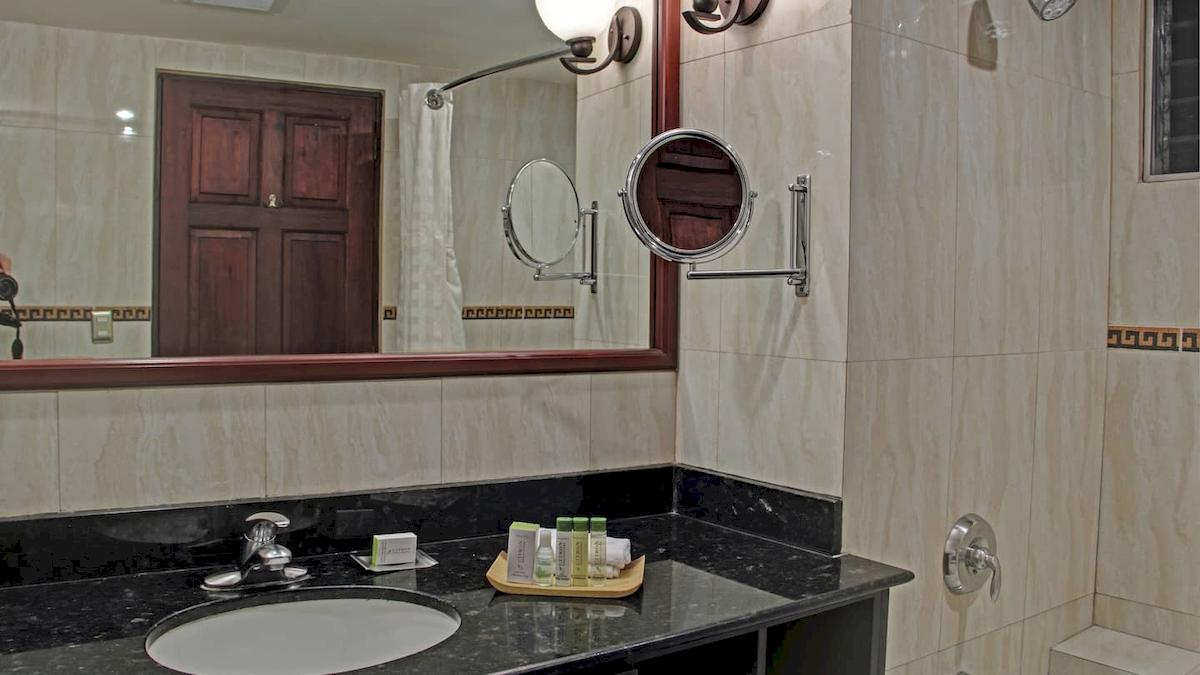 Badezimmer im DoubleTree by Hilton Hotel Cariari San Jose mit Spiegel und Waschbecken.
