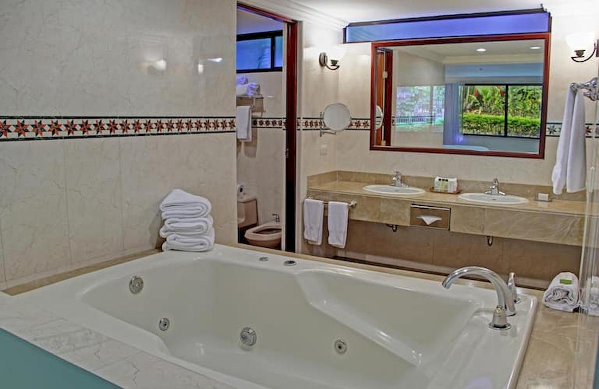 Badezimmer im DoubleTree by Hilton Hotel Cariari San Jose mit Badewanne, Waschbecken und Spiegel.